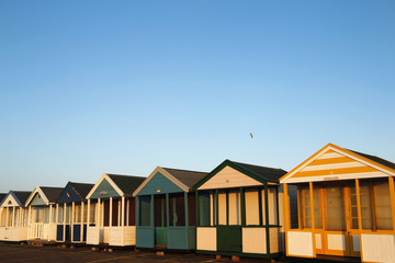 Fototapeta na wymiar Beach huts in golden sunlight