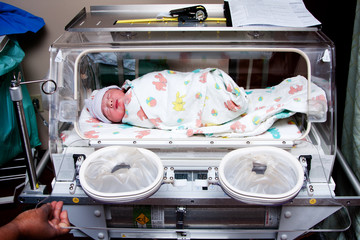 Cute sick baby in incubator