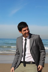 A businessman at the beach, laughing