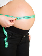 Pregnant woman measuring belly isolated on white