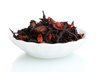 Black dry fruit tea leaves in plate isolated on white