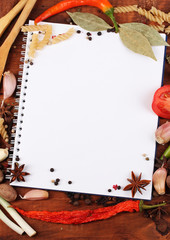 notebook for recipes and spices on wooden table