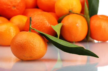 Ripe tasty tangerines with leaves closeup