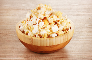 popcorn in wooden bowl on wooden table