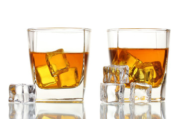 two glasses of scotch whiskey and ice isolated on white