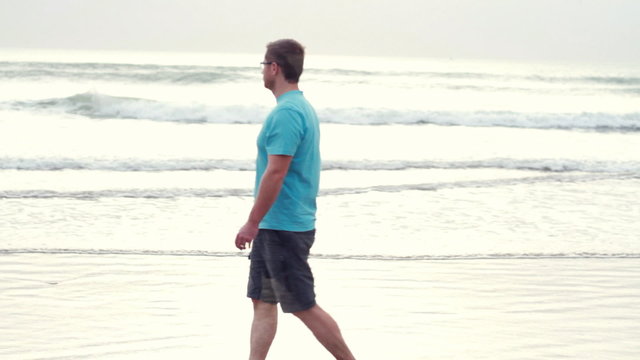 Man walking on beach and looking at the sea