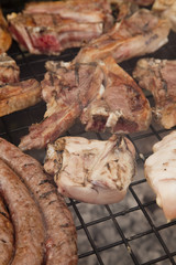 A selection of meats on a wood fire grill