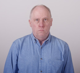 Obraz premium Older Balding Man in Blue Denim Looking Serious