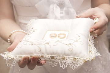 Pair of wedding rings on white pillow