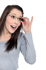 Surprised woman holding her glasses