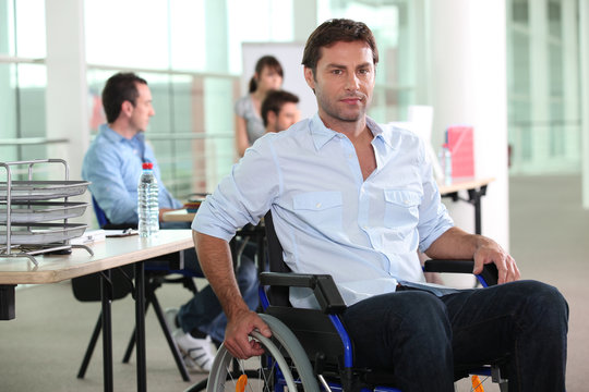 Man using a wheelchair in an office environment