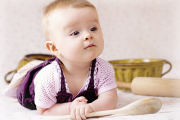Naklejka premium Baby helping in the kitchen
