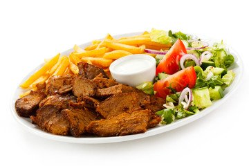 Grilled meat with French fries and vegetables