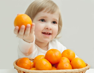 The baby girl is showing the tangerine