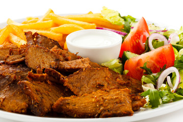 Grilled meat with French fries and vegetables