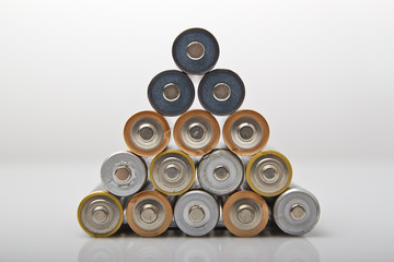 used and new various AA batteries stacked in pyramid shape
