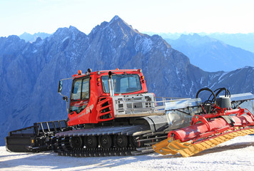 In den bayerischen Alpen: Pistenraupe auf der Zugspitze bei traumhaftem Wetter und Bergblick