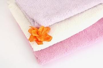 Obraz na płótnie Canvas asciugamani di spugna con fiore arancione