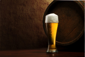 Beer into glass on a old stone and old barrel