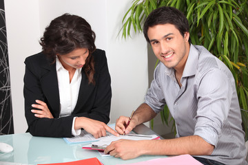 Young man signing a document