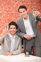 Young men in suits drinking in a wine bar