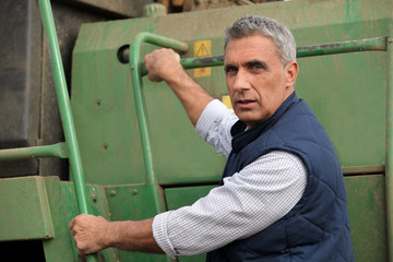 Farmer climbing into a tractor