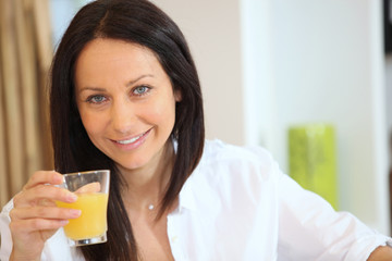 beautiful brunette drinking orange juice