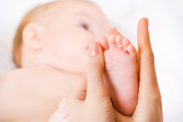 Fototapeta na wymiar mother massaging her child's foot, shallow focus