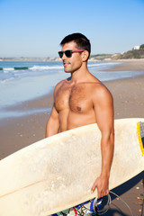 Handsome muscular surfer with surf board