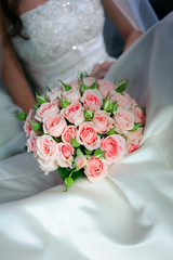 Obraz na płótnie Canvas bride in white dress holding bouquet of roses