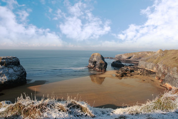 frosty snowcovered coast beach and virgin rock