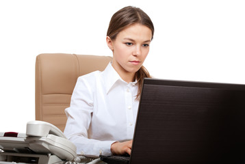 Serious woman at computer in the office workplace