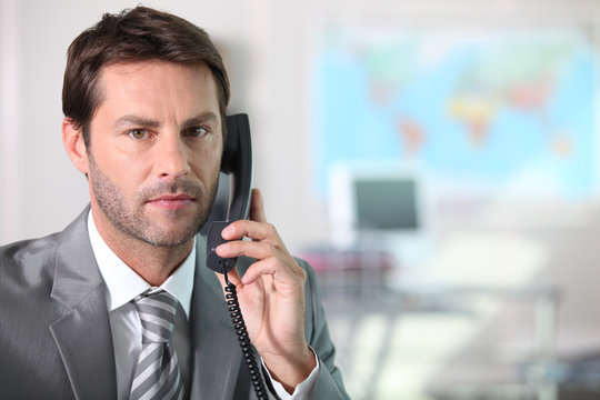 Businessman On The Telephone With Serious Expression On Face