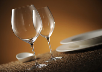 Dinner place setting with plates, glasses and cutlery shallow do