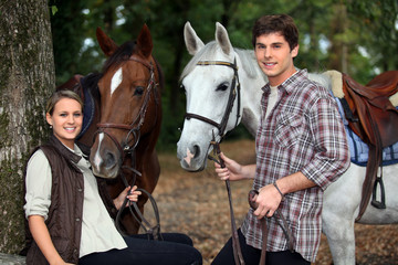 Fototapeta premium young couple and horses in forest