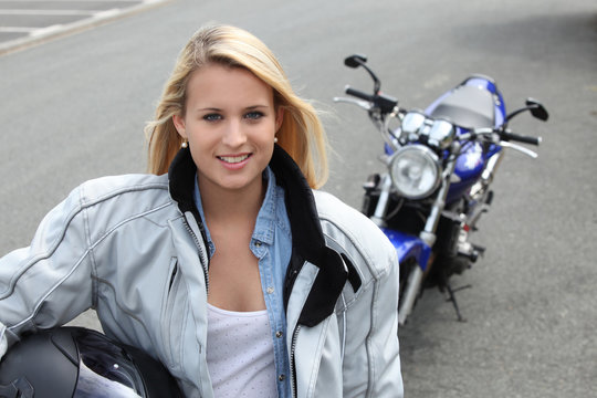 Blond woman stood by motorbike