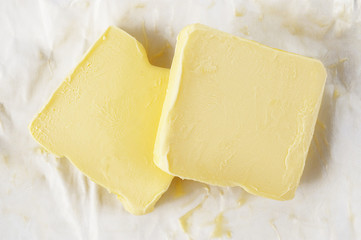 Piece of butter in paper on white background