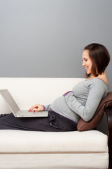 smiley pregnant woman with laptop