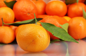 Ripe tasty tangerines with leaves closeup