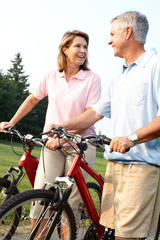 Obraz premium Senior couple cycling in park.