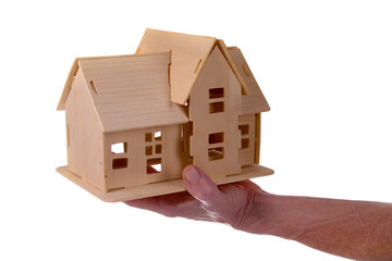 Obraz na płótnie Canvas Hand holding a wooden house