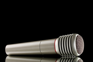 Shiny grey iron microphone on black background
