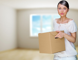 Smiling woman at her home holding boxes. She is Moving at her ne