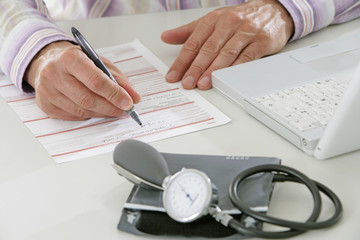 Médecin remplissant une feuille maladie