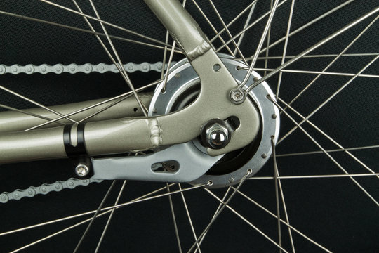 Closeup of rear bicycle wheel hub parts with spokes and chain break