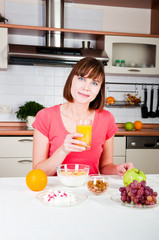 Obraz na płótnie Canvas Young woman drinking orange juice at home