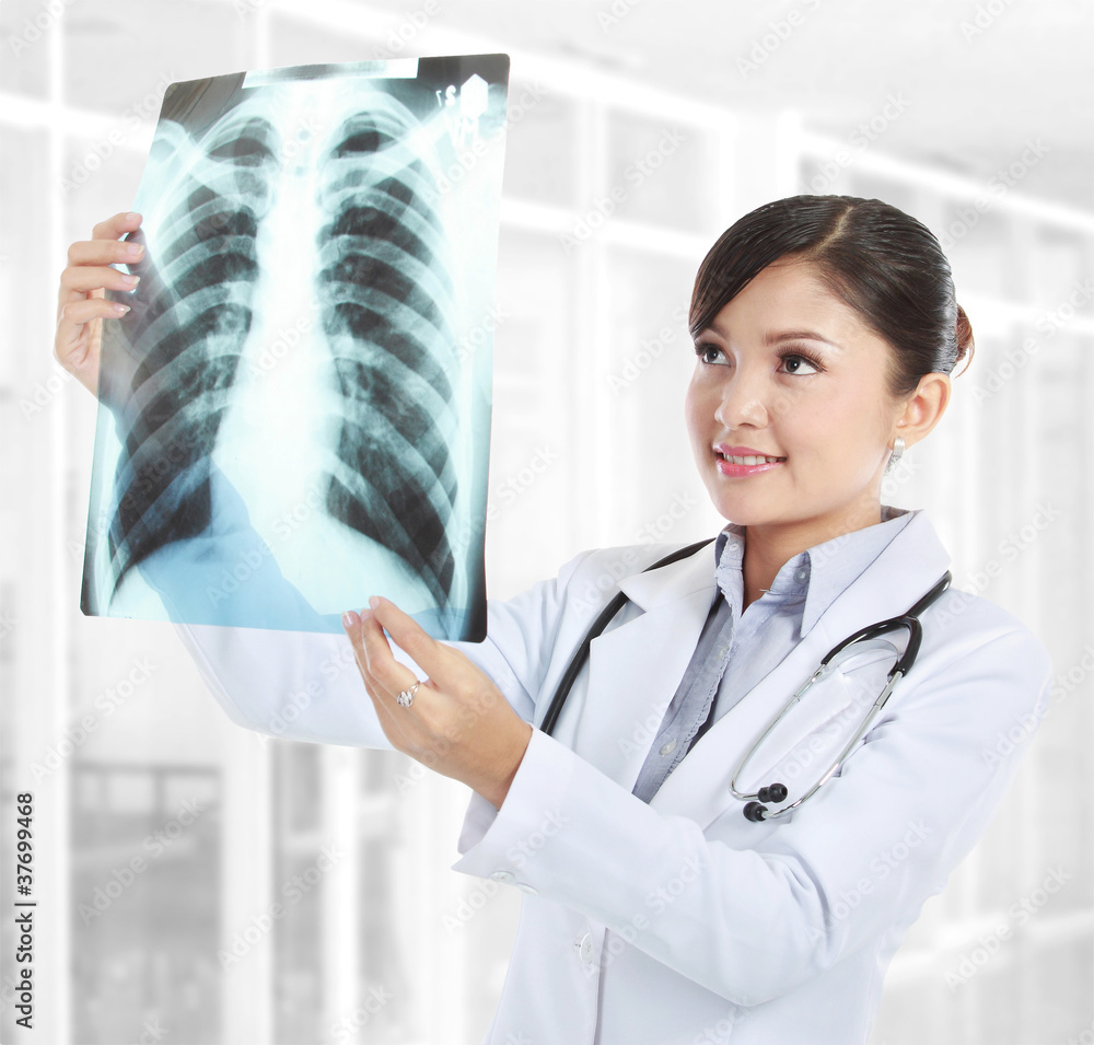 Wall mural female doctor looking at an x-ray