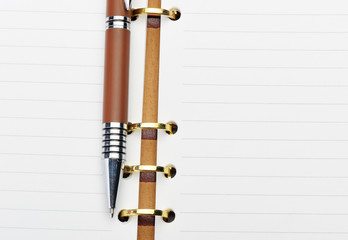 Open notebook with copper binding and stylish pen