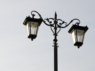 Fototapeta na wymiar Old town street illuminator. Lamps hanging on pole