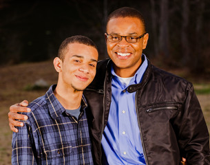Portrait of African-American father and teenage son outdoors